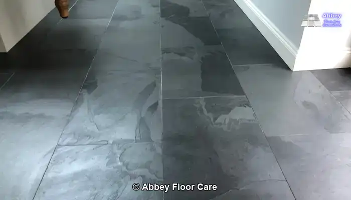 Damp slate floor tiles illustrating the temporary depth homeowners expect from a wet look finish